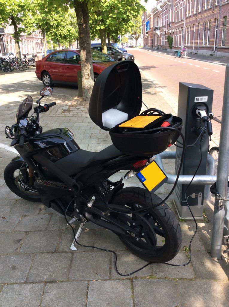 Electric motor cycle with multiple charges is using adapter from Laadkabelfabriek.nl to charge at public charging station